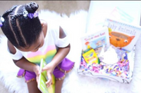 Young child reading beside an Owl Post Books kids subscription box filled with Baby Animals and crafts, a perfect holiday gift for toddlers.
