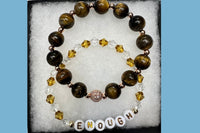 Handmade encouragement bracelet with earthy brown stone beads, amber faux crystal accents, and white letter beads spelling “ENOUGH” 