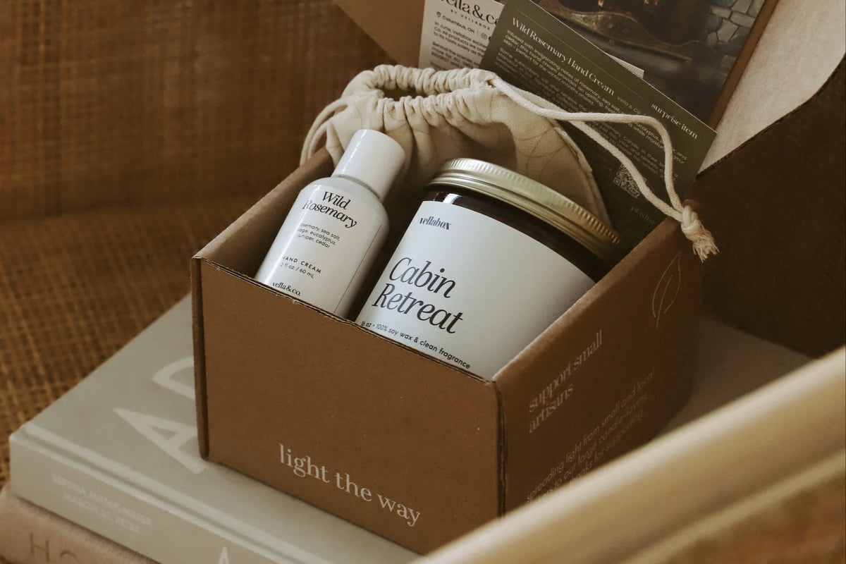 Vellabox Cabin Retreat candle and Wild Rosemary hand cream in an open kraft box