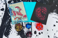 Accessory Example. Each box will contain either 1 dice, a pack of sleeves, or a playmat on rotation. Will differ from picture above.
