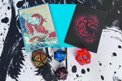 Accessory Example. Each box will contain either 1 dice, a pack of sleeves, or a playmat on rotation. Will differ from picture above.