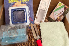 A subscription box full of different kitchen gadgets that are used for cooking, meal prep, or clean up.