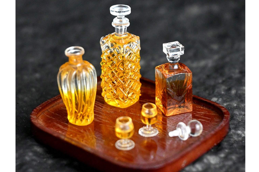 This is a photograph of a tiny miniature cognac set in glass.  They are sitting on a tiny wooden tray. 