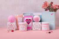 A person holds a teal Bath Bevy monthly subscription box tied with a red ribbon, ideal for self care gifts