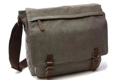 A gray canvas messenger bag featuring a brown adjustable shoulder strap, a zippered front pocket, and two brown leather buckle straps.