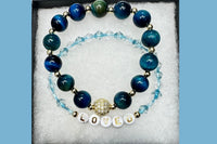 Handmade encouragement bracelet with turquoise stone beads, aqua faux crystal accents, and white letter beads spelling “LOVED” 