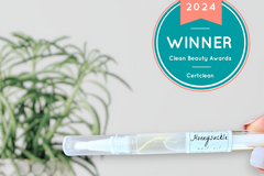 A close up of Greenmade goods Honeysuckle Cuticle Oil, a Clean Beauty Winner badge in the upper right corner against a light background