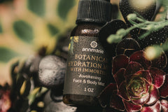 High quality closeup photo of an oil drop skin care product. The whole background is covered by wild flowers.