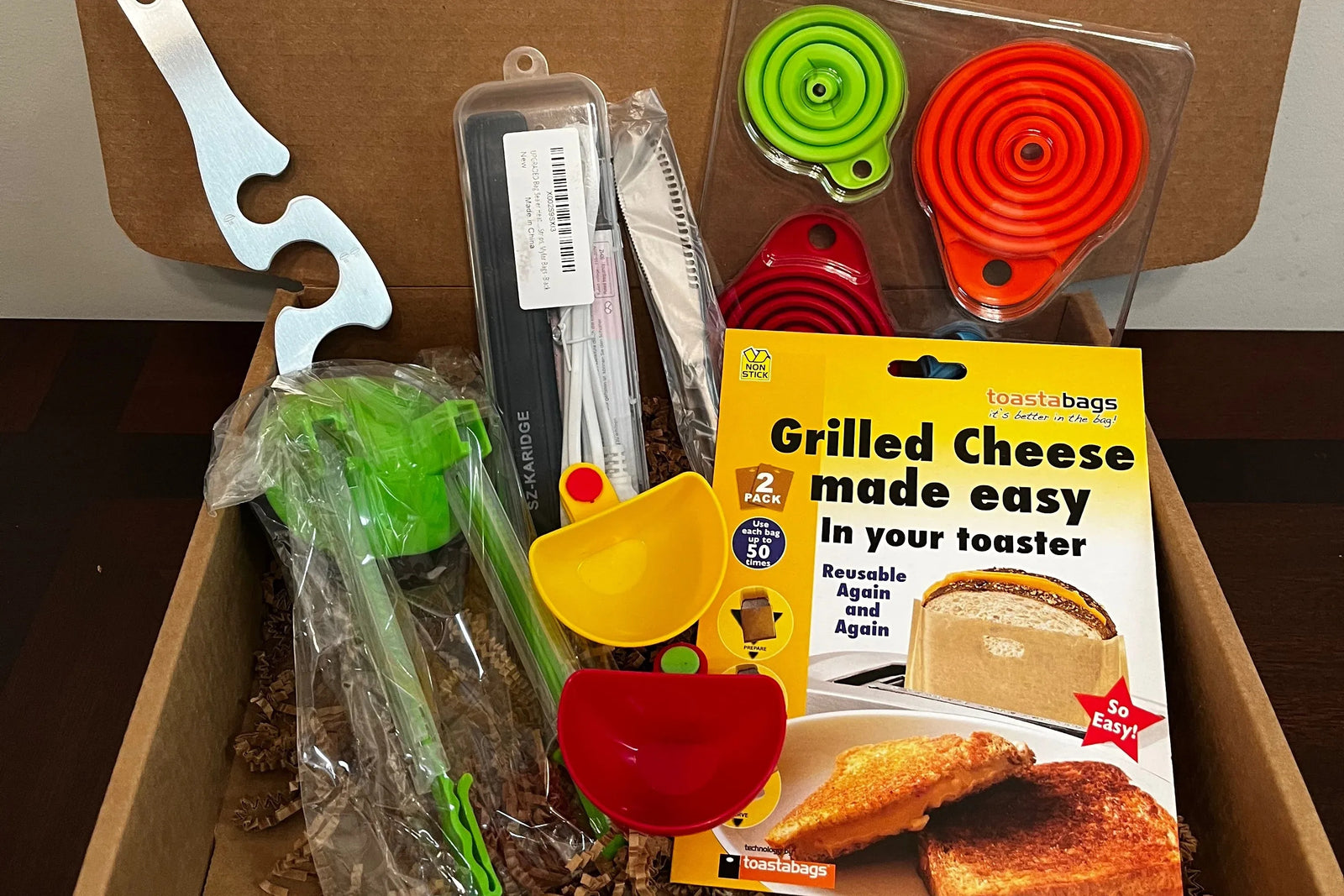 A subscription box full of different kitchen gadgets that are used for cooking, meal prep, or clean up.