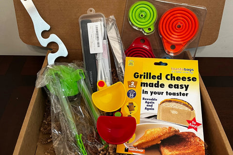 A subscription box full of different kitchen gadgets that are used for cooking, meal prep, or clean up.