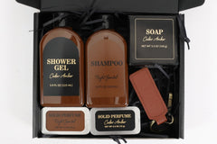 Picture from the above of a shappoo, shower gel and other products for men packed in a box made of black carboard.