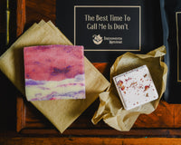 Introverts Read & Relax box contents - close up of soap and shower steamer with insert card on wood table.