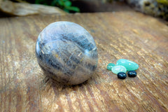 Enchanted Crystal subscription box on wooden table, with single featured crystal of the month and bonus mini crystals
