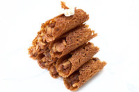 Apple Pie Brandy Snaps DIY baking kit result with 28 filled lace desserts arranged in four neat rows on a white tray.