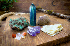 Enchanted Crystal subscription box on wooden table, with multiple crystals arranged and bonus mini crystals