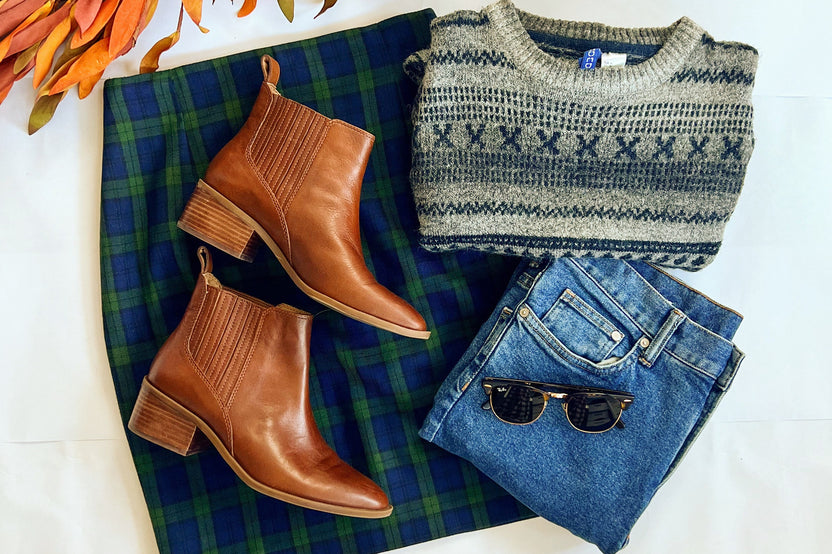 classic outfit flatlay with brown boots, wool mini skirt, vintage sweater and denim to match along with sunglasses