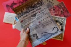 Scarlet Envelope Secret Society subscription box with red envelope, mystery clues, and a glass of wine for a date night experience