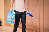 Photo of home owner using Remedy's easy-to-use DIY pest control kit on garage door of home. All supplies that are needed come with the kit.