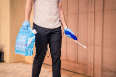 Photo of home owner using Remedy's easy-to-use DIY pest control kit on garage door of home. All supplies that are needed come with the kit.