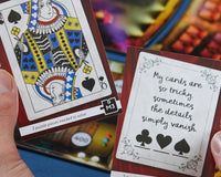 A person holding 2 cards that are from a mystery thrilling escape game and a board deck in the background.