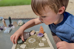 child working with crystals, focused on selecting them, engaging in organization and exploration with crystals