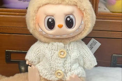This is a warm cable knit sweater in color cream with buttons for your Labubu doll. Labubu doll not included
