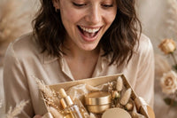 model is excited about receiving a gold gift box in silk ribbon with gold themed skincare products while unboxing each product one by one