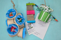 A variety of bird toys laid out on a blue cloth. Next to it is an itemized receipt and a business card. 
