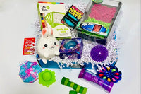 Teen Box with pin print, squish needoh cats, magnets, Squishable bunny, spinner, bubble notepad, textured brush, spiky ball, swirl globe