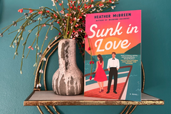 Paperback of Sunk in Love by Heather McBreen agains a teal background. Contemporary romance. Second chance romance, Forced Proximity.