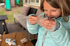 child working with crystals, focused on selecting them, engaging in organization and exploration with crystals