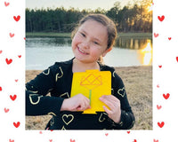 Happy child with February Activity Box. February Valentine's box with 20 OT activities, crafts, sensory materials, and fine motor tools for 