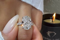 this photo show a diamond 5 carton ring with several facets sparkling with a flaming candle in the background