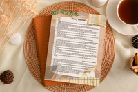 Story Starters writing prompt sheet on a wicker plate with a candle, tea, pinecones, and dried florals, from the Journey Box.