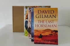 Brown subscription box filled with four fantasy novels, featuring magical worlds and adventurous plots for fans of imaginative storytelling
