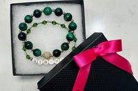 Handmade encouragement bracelet with rich green stone beads, clear and green faux crystal accents, and white letter beads spelling “STRONG” 