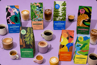 a purple scene of coffee bags, cups, part of Goodbirds monthly coffee subscription of 2 12oz bags of coffee