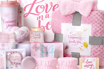 a pink themed spa and wellness box featuring 10 full size items from fuzzy socks, a heart bath bomb, soy candle, a pink beaded bracelet + mo
