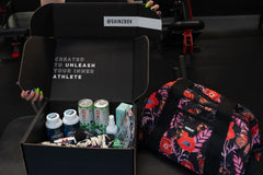 This photo shows an open Gainz Box of the Q3 2024 variety, highlighting different products in the box, including a colorful Vooray duffel.