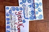 Hand-decorated patriotic envelope with blue swirl designs, handwritten sample name and U.S. address, shown with matching stationery.