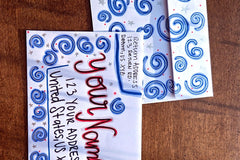 Hand-decorated patriotic envelope with blue swirl designs, handwritten sample name and U.S. address, shown with matching stationery.