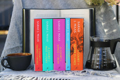 Set of allined books from one series of romance with a coffe much on the left and a bigger one on the right.