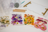 Pressed floral designs on cardstock with a clear serving tray and crafting tools from The Adults & Crafts Crate subscription box