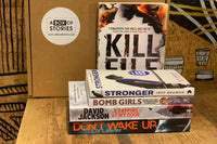 Brown box filled with a diverse collection of books in multiple genres, including crime thrillers, romance, and fantasy