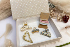 another example of an open box of curated hair accessories with a variety of hair ties, clips, and bows.