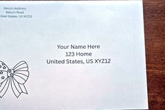 White envelope with printed sample U.S. mailing and return addresses, featuring a black outline patriotic bow design on the left.