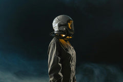 Futuristic looking photo with white smoke around the sides of a person weraring space looking and futuristic suit with helmet on.