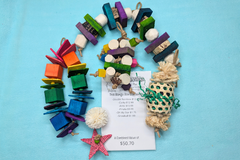 A variety of bird toys spilling out of a cardboard box and onto a blue cloth. Next to it is an itemized receipt.