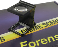 A blue box containing a forensikit is displayed in the back while a magnifier device is in the foreground