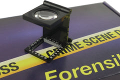A blue box containing a forensikit is displayed in the back while a magnifier device is in the foreground